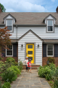 A bright yellow door reflects the homeowners’ love of color,